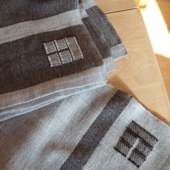 Swans Island Company's Island Throws are made with locally sourced single-origin fleece from a Maine island farm. Shown here, brown with grey stripes and grey with brown stripes throws.