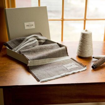 Swans Island Company - Island Collection Scarf in brown with natural grey stripes. Handwoven in Maine using single-origin wool from Long Cove Farm on Vinalhaven Island, Maine. Scarves come in a grey linen gift box.