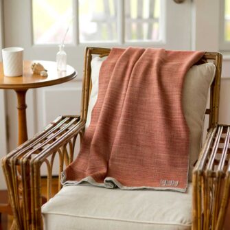 Swans Island Company's Katahdin throw is handwoven in Maine with all natural hand-dyed organic merino wool, Shown here in Bittersweet.