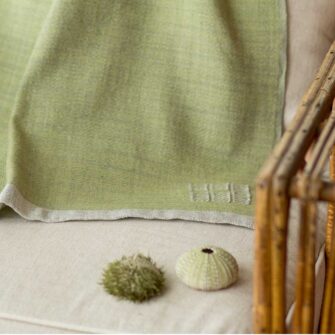 Swans Island Company's Katahdin throw is handwoven in Maine with all natural hand-dyed organic merino wool, Shown here in Thyme.