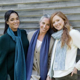 Swans Island Company's Watercolor Scarf is hand-dyed with all-natural indigo and other natural dyes. Handwoven in Maine. Shown here in Teal, Beetroot, and Natural.