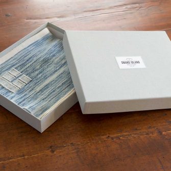 Swans Island handwoven scarf in custom grey linen gift box.