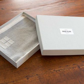 Swans Island handwoven scarf in custom grey linen gift box.