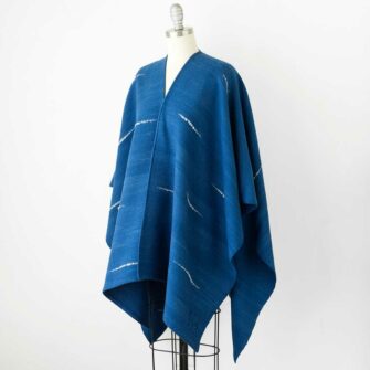 Swans Island's Whitecaps Cape, handwoven in Maine with hand-dyed organic merino wool. Indigo with Natural colorway.