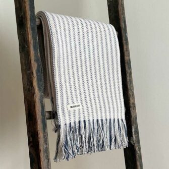 Swans Island's Cotton Ticking Throw Fringe blanket is woven in Maine with 100% American cotton.