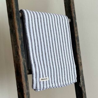 Swans Island's Cotton Ticking Throw blanket is woven in Maine with 100% American cotton.
