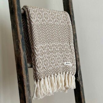 Swans Island's Starburst Throw blanket is woven in Maine with 100% American cotton and features a hand-tied fringe.