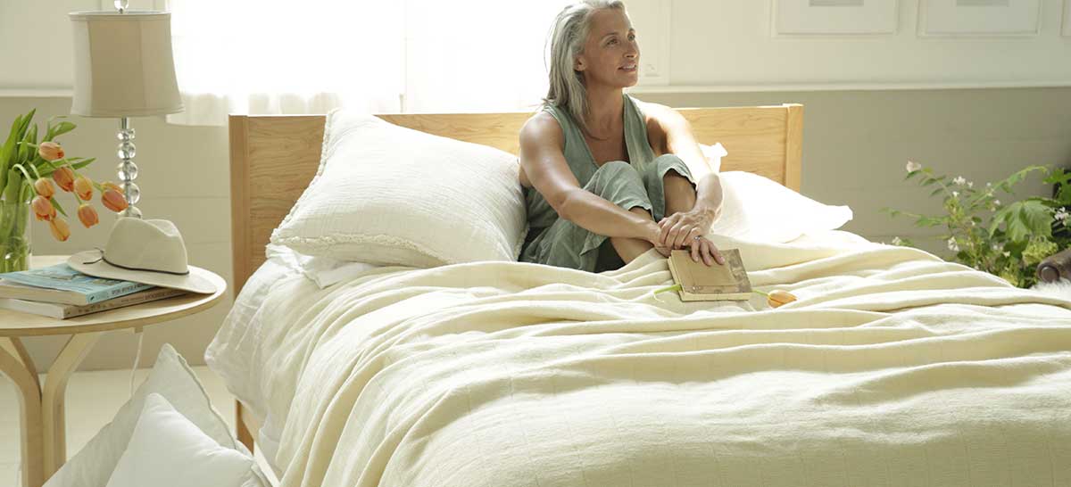 woman holding book while sitting in bed
