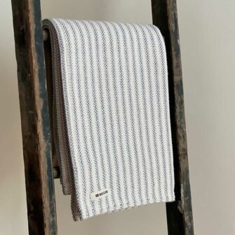 Swans Island's Cotton Ticking Throw blanket is woven in Maine with 100% American cotton.