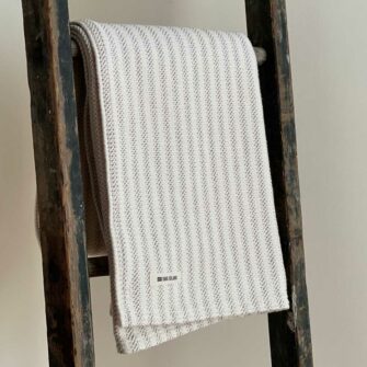 Swans Island's Cotton Ticking Throw blanket is woven in Maine with 100% American cotton.