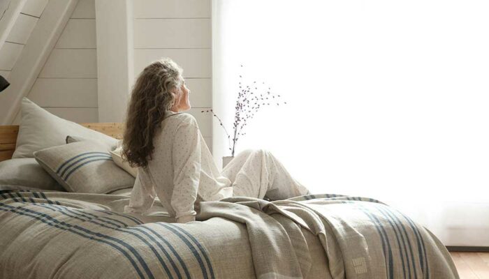woman seated on bed with Heritage Blanket