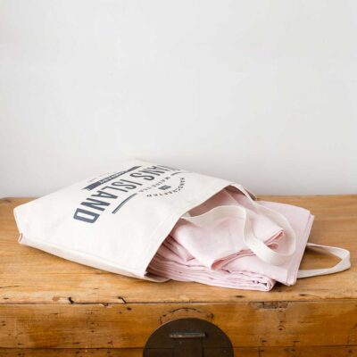 Swans Island Company's Relaxed Linen Sheet Set is made with 100% French linen, stitched in the USA. Sheet set, shown here in Blush, comes in our custom canvas tote bag.