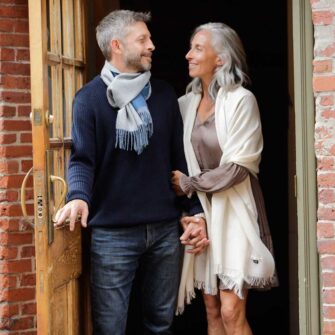 Swans Island Company's Alpaca Whisper Shawl - handwoven in Peru with the softest baby alpaca. Airy and light yet worm and soft - with an unexpected pop of color along the edge. Shown here in Ivory with Sky Blue edge.