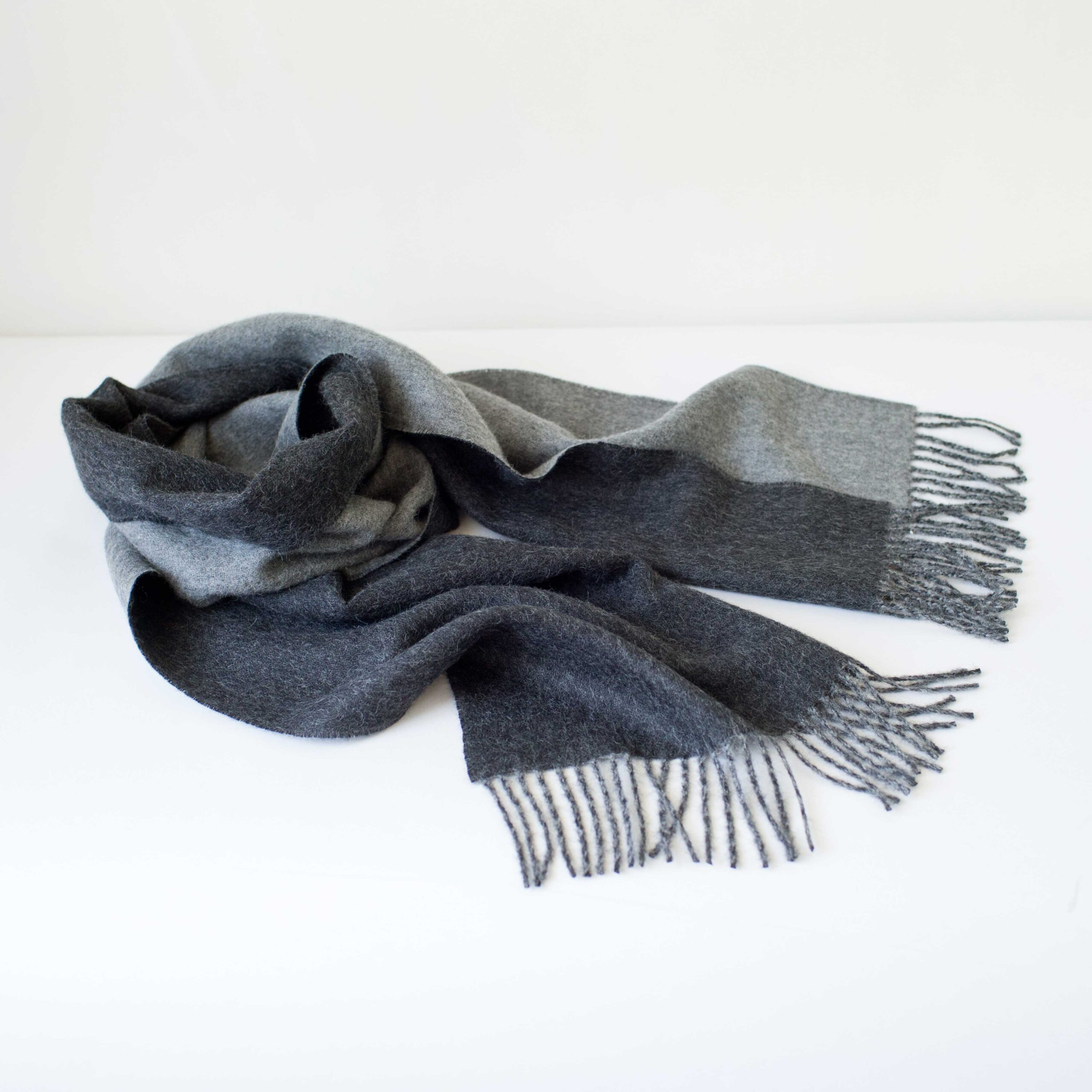 Swans Island Company's Reversible Baby Alpaca Scarf is a luxurious, soft scarf for men and women. Shown here in Charcoal /LIght Gray colorway.