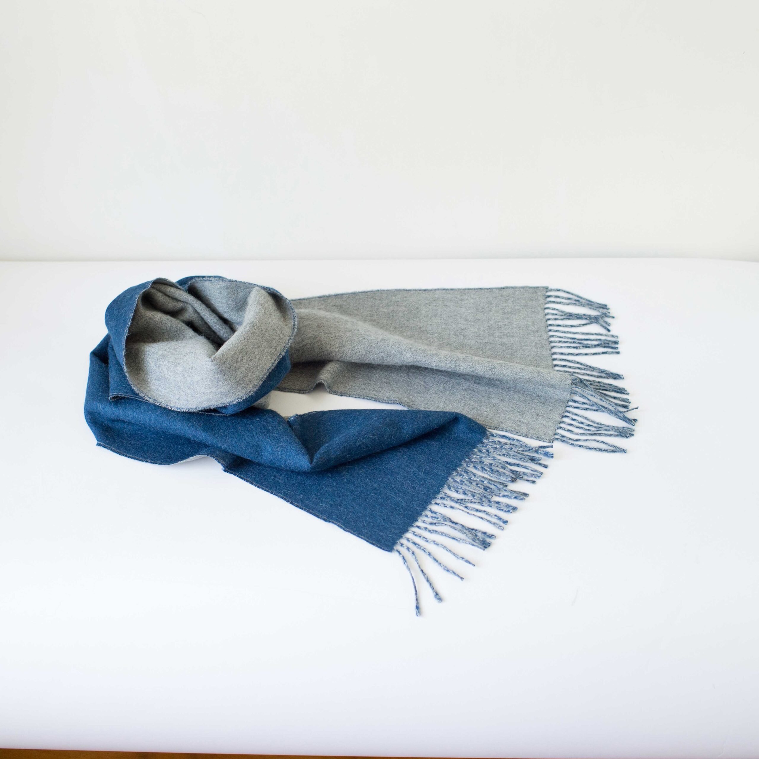 Swans Island Company's Reversible Baby Alpaca Scarf is a luxurious, soft scarf for men and women. Shown here in Lt. Grey / Marine Blue colorway.