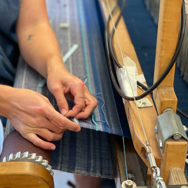 Swans Island Co. Ocean Limited Edition Throws - Chloe, at the loom weaving one of the eleven unique throws.