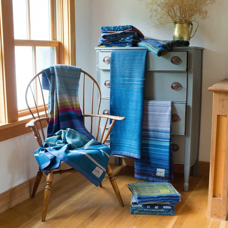 Swans Island Co. Ocean Limited Edition Throws 2023 - 11 unique handwoven throws, draped on chair and dresser.