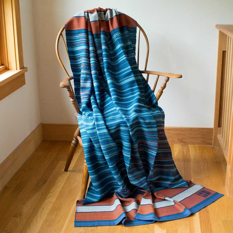 Swans Island Co.'s Limited Edition Ocean Series - Throw #10 "Atlantic Sunset" is handwoven in Maine. One of a kind. Closeup detail of handwoven coral and ivory striped border.