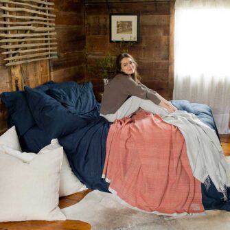 Swans Island Company's Relaxed Linen Bedding Bundle. 100% French linen made in the USA, breathable, soft and regulates temperature as you sleep. Shown here in Midnight Blue with our handwoven wool Katahdin Blanket in Bittersweet.