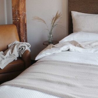 Swans Island Company's Charisma Blanket. Soft 100% Cotton blanket with woven herringbone texture. Made in USA with 100% American cotton. Shown here in Taupe.