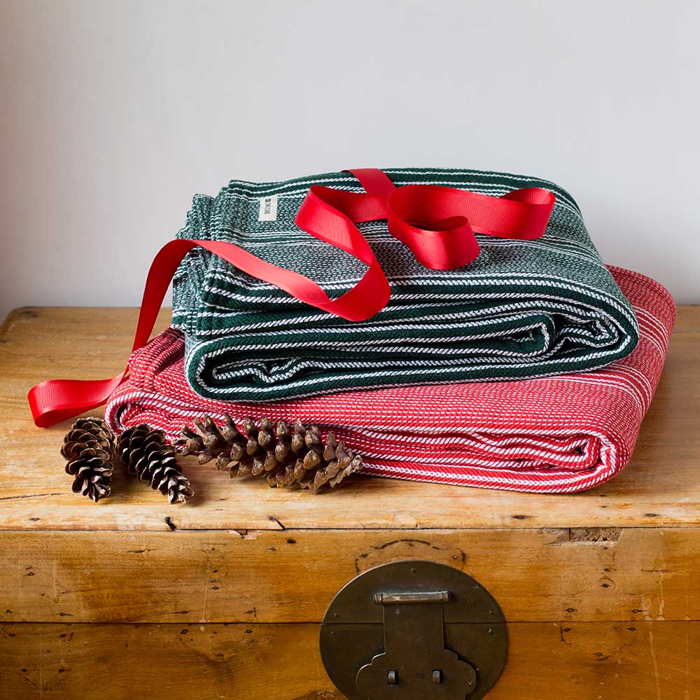 Swans Island Company's Cotton Pick Stripe Blanket. Soft 100% Cotton blanket with yarn-dyed woven stripes. Made in USA with 100% American cotton. Shown here in holiday Red and Green.