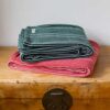 Swans Island Company's Cotton Pick Stripe Blanket. Soft 100% Cotton blanket with yarn-dyed woven stripes. Made in USA with 100% American cotton. Shown here in holiday Red and Green.