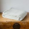 Swans Island Company's Savannah Blanket. Soft 100% Cotton blanket with woven herringbone texture. Made in USA with 100% American cotton. Shown here in Bayleaf.