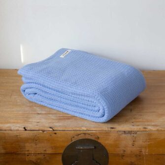 Swans Island Company's Tuscany Cotton Blanket. Soft 100% Cotton blanket woven with an allover basketweave texture. Made in Maine, USA. Shown here in French Blue.