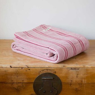 Swans Island Company's Cotton Tulare Blanket. Soft 100% Cotton blanket with yarn-dyed woven stripes. Made in USA with 100% American cotton. Shown here in Rose.