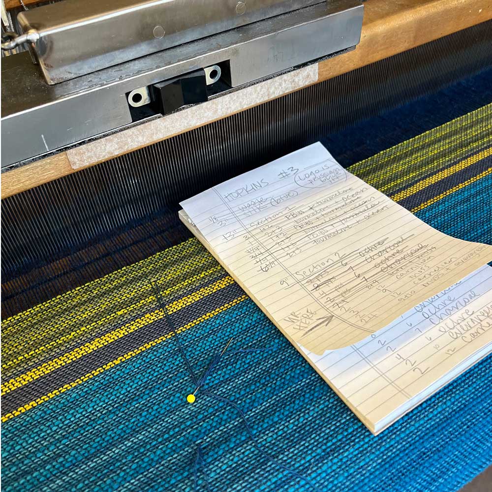 The Swans Island & Eric Hopkins Ltd. Edition Throw 2024. A closeup of the weaver's instruction notes, on the loom at Swans Island studios, Northport, Maine.