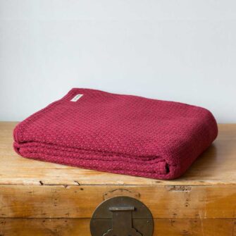 Swans Island Company's Mackenzie blanket is woven in Maine with soft 100% American Cotton. Shown here in Red.
