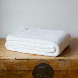 Swans Island Company's Mackenzie blanket is woven in Maine with soft 100% American Cotton. Shown here in White.