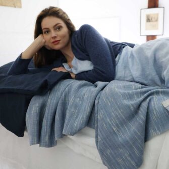 Swans Island Company's Coastal Cottage Bedding Bundle. Includes 1 Classic Linen Sheet Set in white + 1 Relaxed Linen Duvet Set in Midnight Blue. Shown here with our handwoven Firefly blanket in Twilight color.