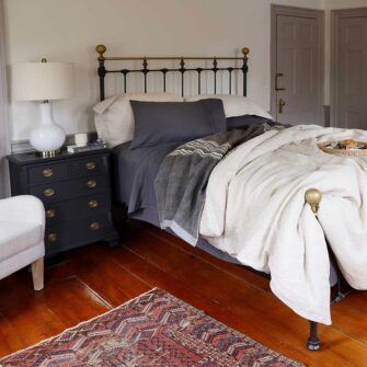 Swans Island Company's Stone Coast Linen Bedding Bundle. Includes 1 Relaxed Linen Sheet Set in Obsidian + 1 Classic Linen Duvet Set in Flax. Shown here paired with a Signature signature handwoven Grace Winter wool blanket in Charcoal.