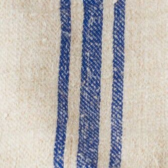 Swans Island Company's Quilt Basket Bag by Govou. Handcrafted in Spain from vintage linen grain sacks. Long canvas shoulder straps and short handles, lined with cotton. Each bag is unique. Shown here in natural with blue stripes. Swatch