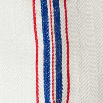 Swans Island Company's Quilt Basket Bag by Govou. Handcrafted in Spain from vintage linen grain sacks. Long canvas shoulder straps and short handles, lined with cotton. Each bag is unique. Shown here in natural with red and blue stripes. Swatch