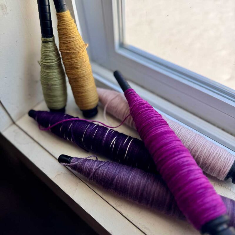 colorful yarn bobbins on windowsill