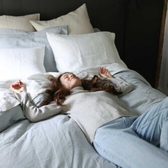 Swans Island Company's Relaxed Linen Bedding. Elegant French linen stitched in the USA for those seeking a refined and timeless sleep experience. Shown here in Sea Spray Duvet cover and shams, paired with with Classic White Sheets.