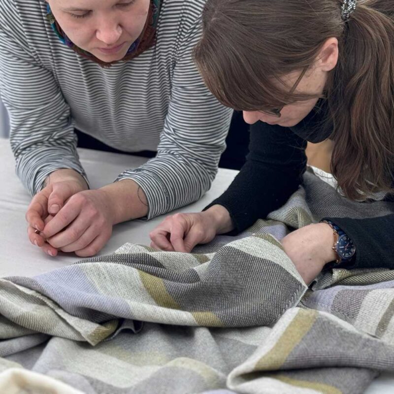 woman stitching throw