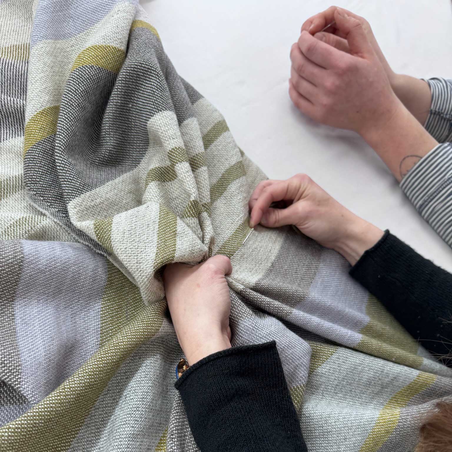 hands stitching handwoven throw