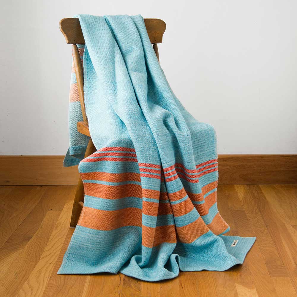 Swans Island x Pierrepont Hicks Wool Camp Blanket - handwoven in Maine with hand-dyed wool. Inspired by camp blankets of the past, woven in colors of today - a bold turquoise ground with shades of orange stripes in the borders.