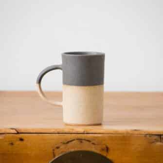 Swans Island Company's Tall Dipped Mugs are handcrafted with stoneware pottery dipped with a food-safe earthy glaze on top. Made in Maine. Shown here in Charcoal.