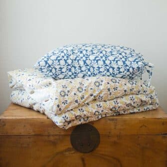 Swans Island Abha Duvet Cover by Soil to Studio. Block printed by hand in India with bright playful patterns. Shown here in natural with gold and blue floral. Mix and Match with Amna shams shown here.
