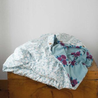 Swans Island Company's Sara Duvet Cover by Soil to Studio. Block printed by hand in India with bright playful patterns. Shown here in Denim with roses.