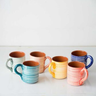 Swans Island Compass Classic Terracotta Striped Mug. Handcrafted in Portugal. Shown here in a variety of cheerful colors.