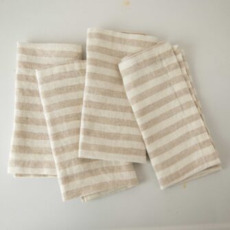 Swans Island Company's linen napkins by Linen Tales, made with 100% European Linen Oeko-Tex® and EUROPEN FLAX® certified. Made with stonewashed soft linen with mitered corners for a crisp edge. Shown here in Natural White Stripe. Set of 4