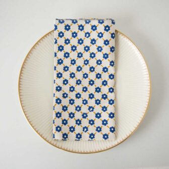 Swans Island Company's Pia Napkins by Soil to Studio. Block printed by hand in India with bright playful patterns. Shown here in Natural with yellow and blue.