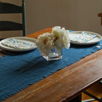 Swans Island Company's linen table runner by Linen Tales, made with 100% European Linen Oeko-Tex® and EUROPEN FLAX® certified. Made with stonewashed soft linen with mitered corners for a crisp edge. Shown here in Navy Blue color.