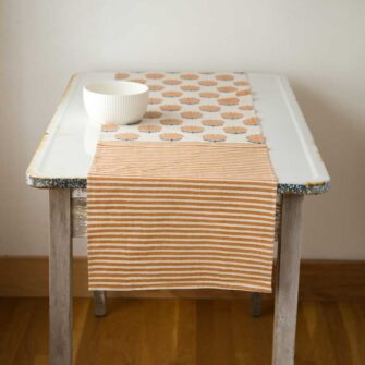 Swans Island Alisha Table Runner by Soil to Studio. Block printed by hand in India with bright playful patterns. Shown here in Natural with Yam.