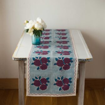Swans Island Sara Table Runner by Soil to Studio. Block printed by hand in India with bright playful patterns. Shown here in Denim Blue with Beetroot Floral.